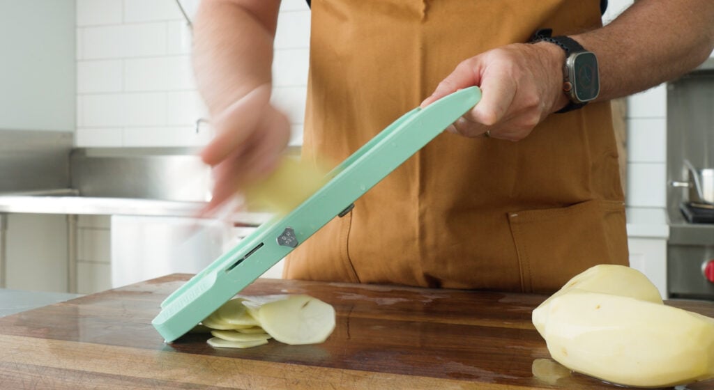 slicing a potato with a mandoline