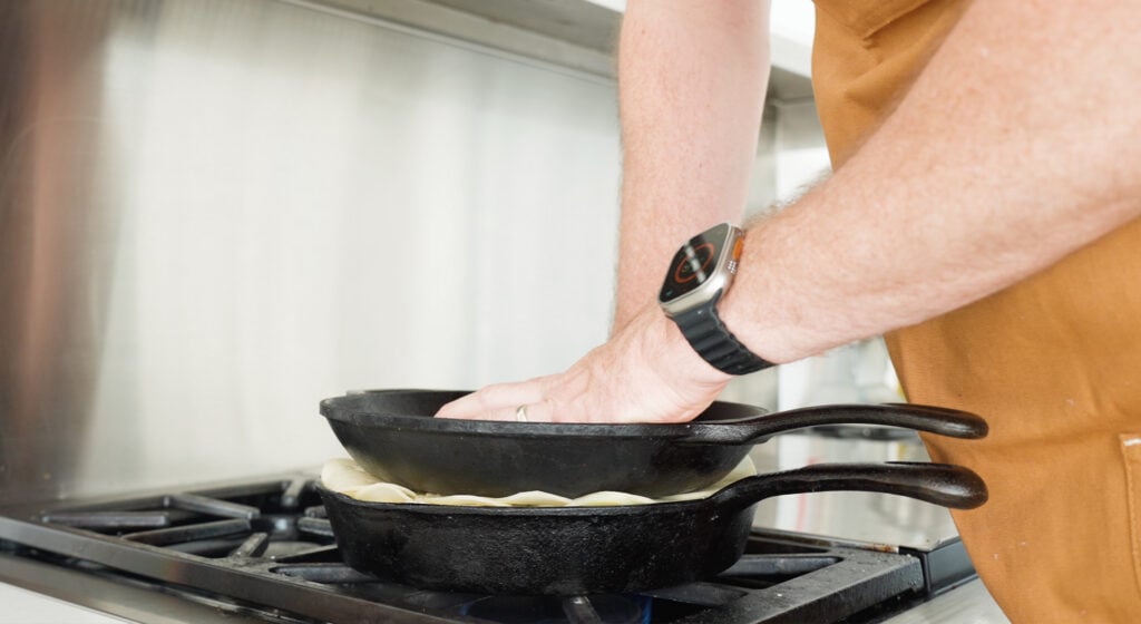 Pressing a smaller skillet on top of the potatoes in a larger skillet