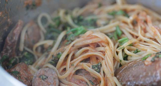 mixing pasta with veggies