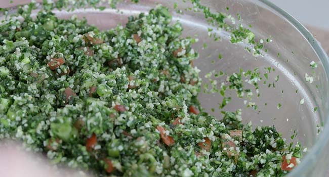 mixing together a tabouli salad