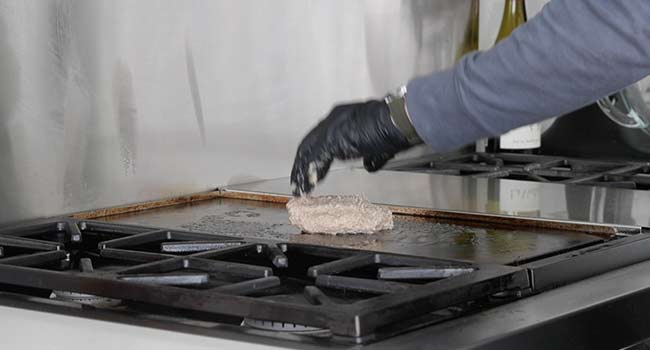 adding a turkey burger to a griddle