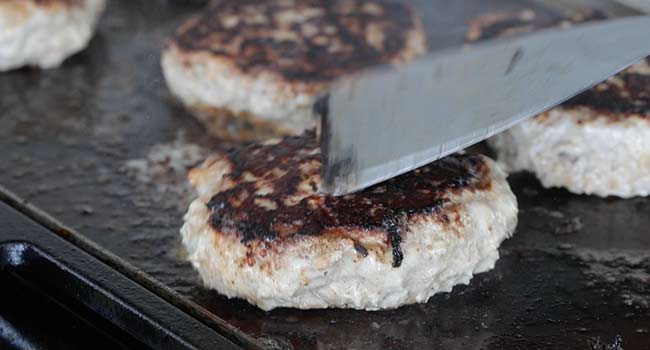 flipping over a seared turkey burger