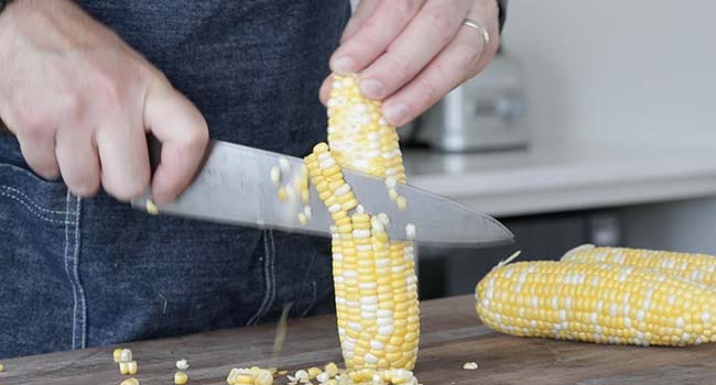 trimming corn off the cob