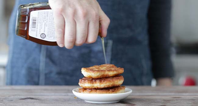adding maple syrup to corn fritters