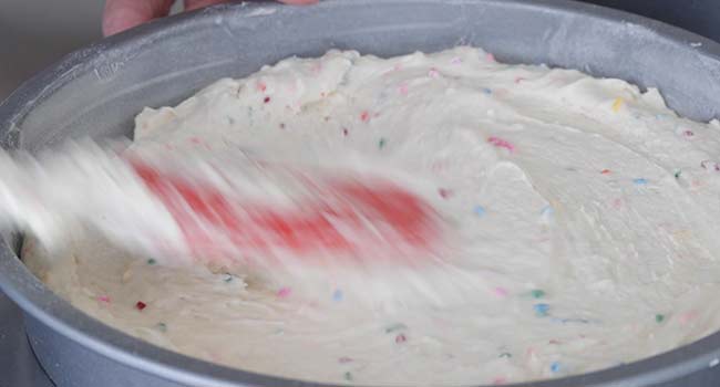 adding batter to cake pans