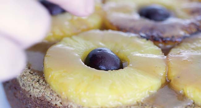 adding cherries to a pineapple upside down cake