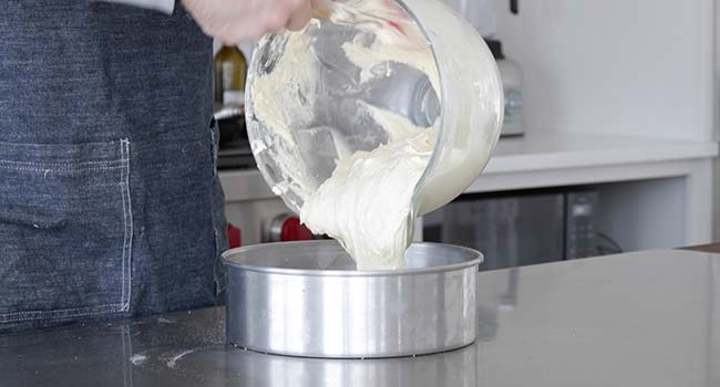 pouring batter into a cake pan