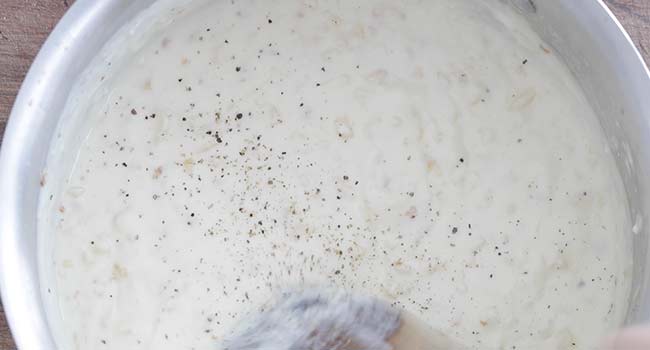 mixing together seasoning into a cream sauce