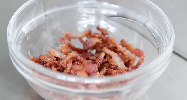 adding crispy bacon to a bowl