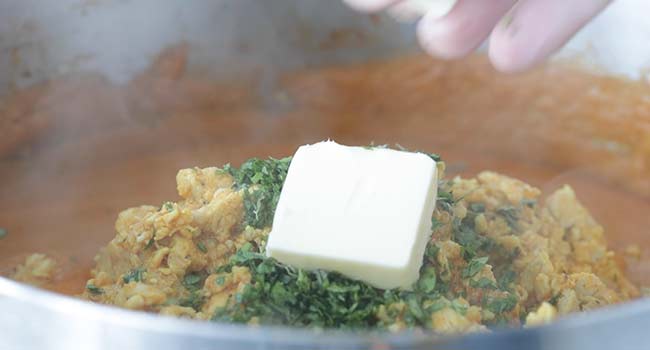 finishing butter chicken with butter and cilantro