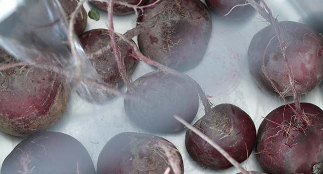 adding water to a pot of beets