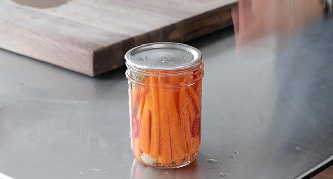 sealing a jar of pickled carrots