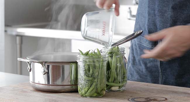 pouring a hot brine over green beans