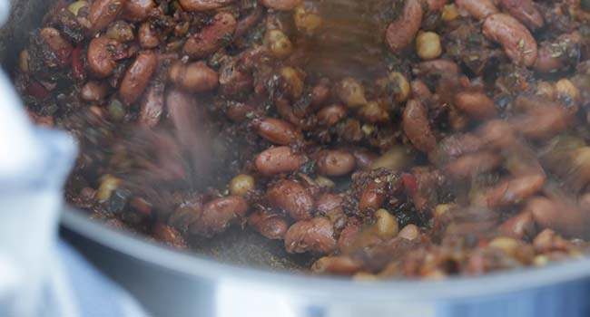 stirring spices with vegetables and beans