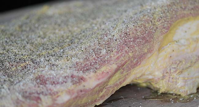 seasoning a brisket with salt and pepper