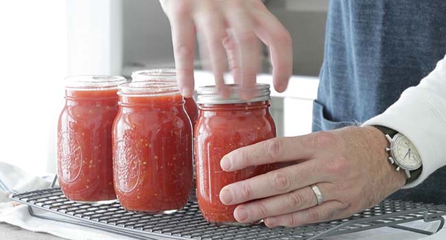 screwing on the lid of a canned tomato jar