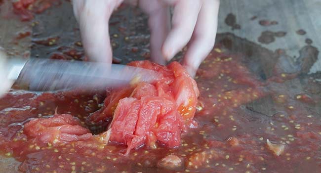 chopping peeled tomatoes