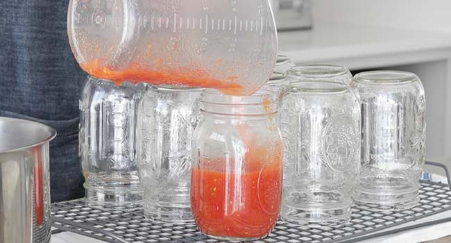 filling jars with cooked tomatoes