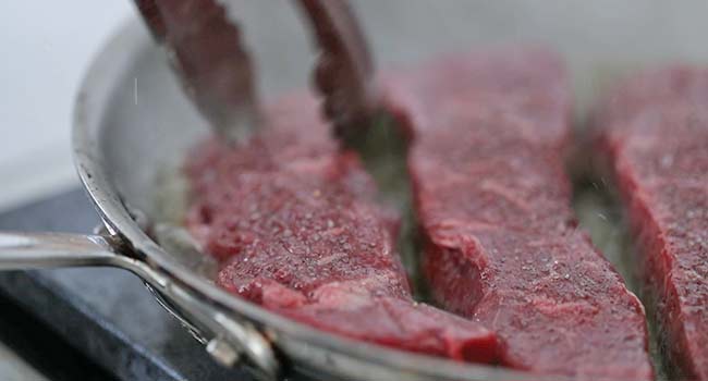 adding coulotte steaks to a pan