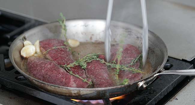 moving steaks around a pan