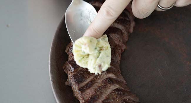 adding butter to sliced steak