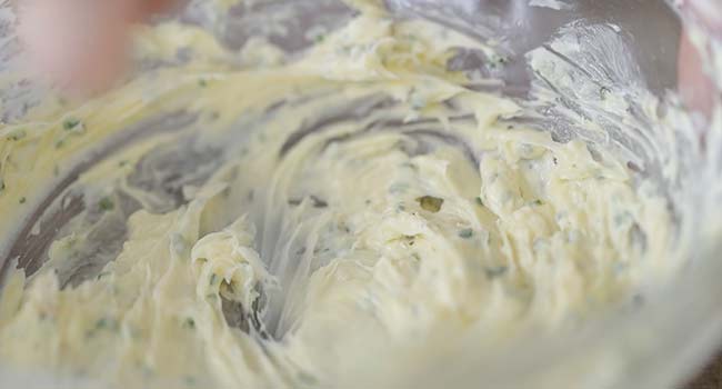 mixing together a roasted garlic butter