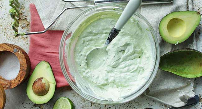 mixing sour cream with mashed avocados