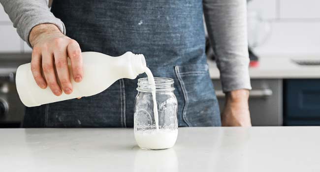 adding milk to a jar