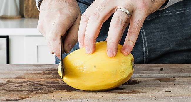 slicing off the end of a mango