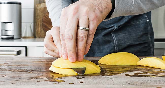 slicing a mango slice in half
