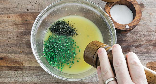 adding herbs and seasonings to a vinaigrette 