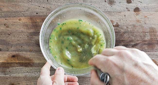 whisking together a lemon vinaigrette