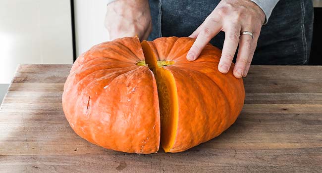 slicing a pumpkin in half