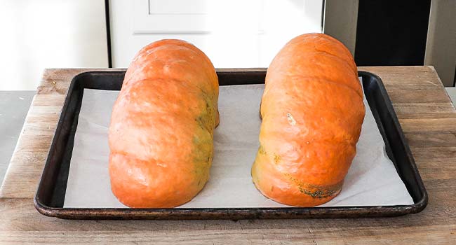 adding pumpkins to a sheet tray