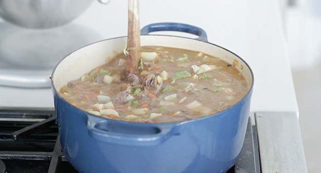 adding liquid to a ot of vegetables