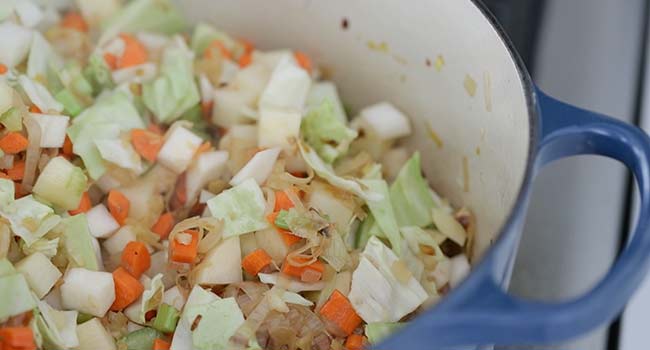 adding vegetables to a pot