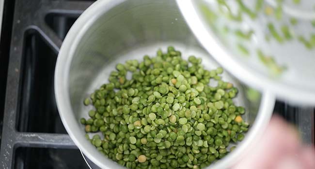 adding water to a pot with split peas