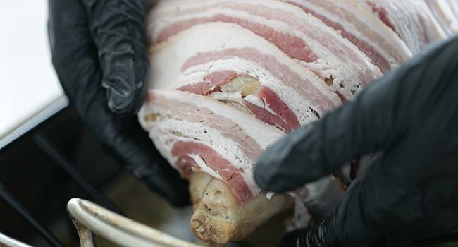 covering a turkey with strips of bacon