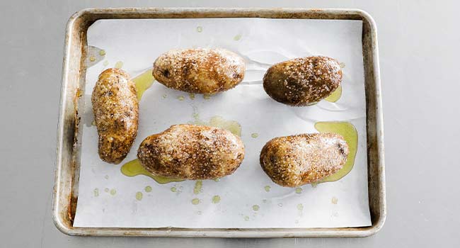 oil and salted coated potatoes on a sheet tray