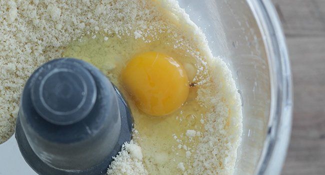 adding an egg to dough