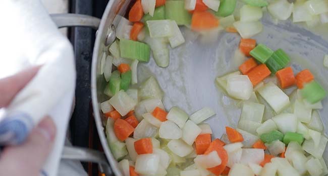 sautéing vegetables in a pan