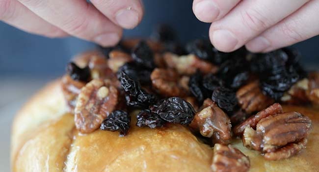 adding pecans and cherries to puff pastry