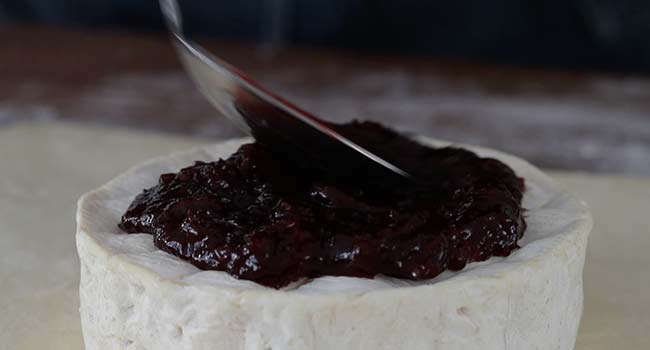 spreading jam on brie