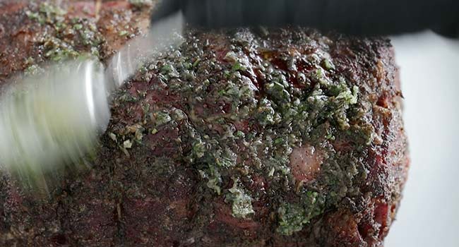 adding herbs to a smoked prime rib