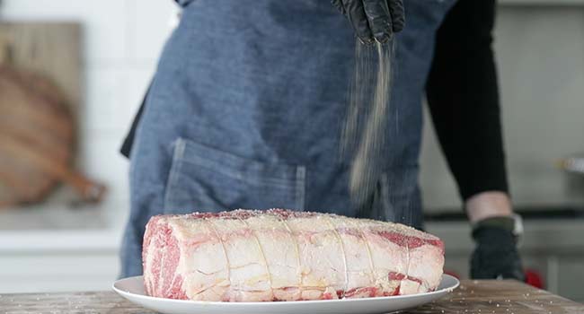 seasoning a prime rib with salt and pepper
