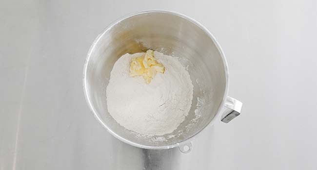 adding flour and butter to a mixing bowl