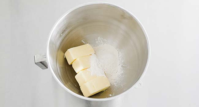 adding butter and flour to a bowl