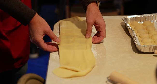 adding flour to a ravioli mold