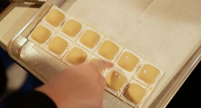 adding ravioli to a sheet tray