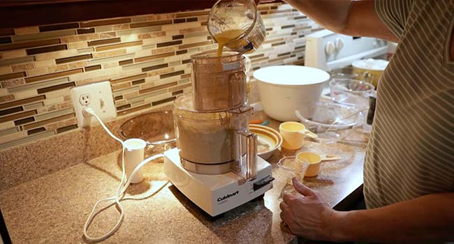 adding eggs to a processor with flour